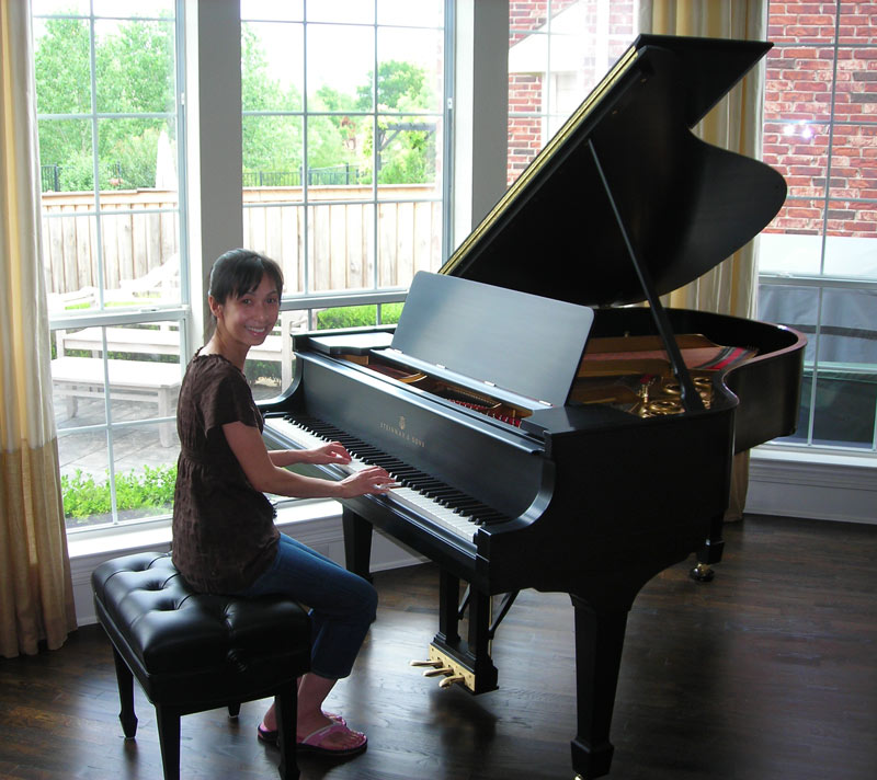 The happy owner is sitting next to the better than new piano with satin finish.