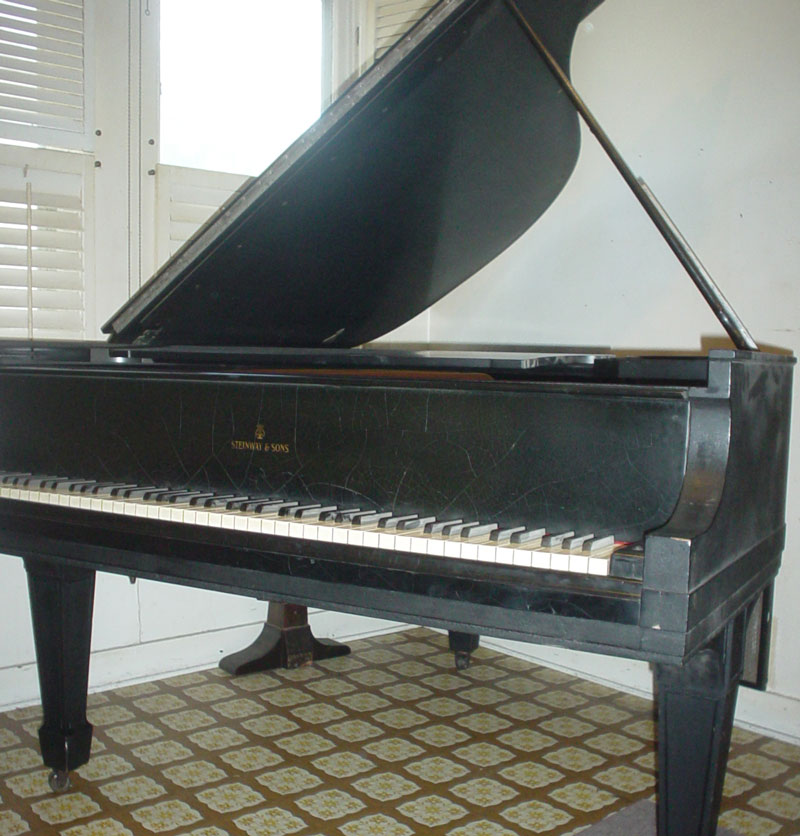 Piano showing chips and scratches.